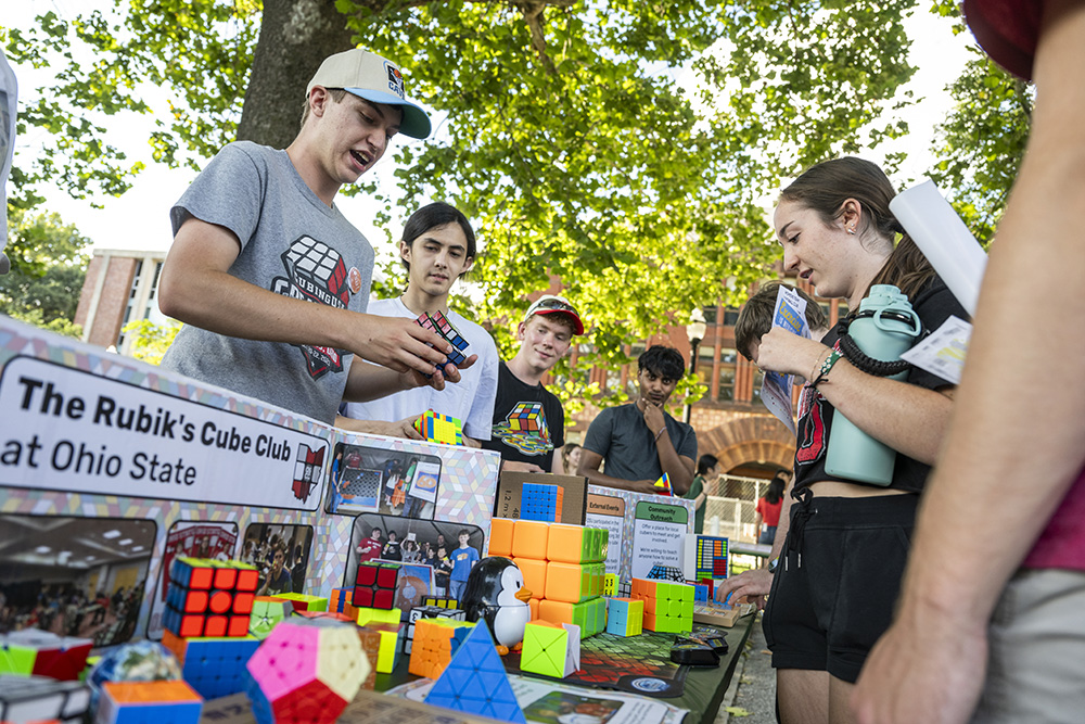 Students at a table with Rubik's cubes during the Student Involvement Fair on the Oval