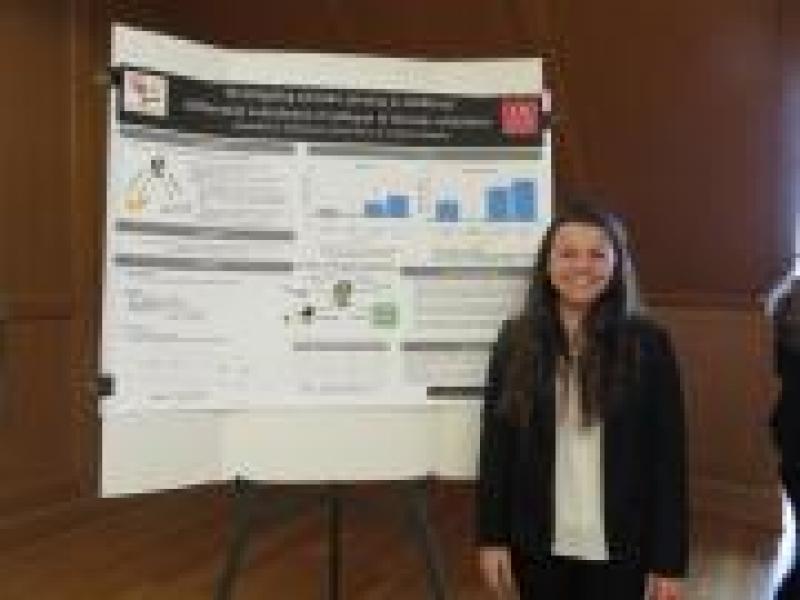 Alexandria Barkhimer next to her second place poster at CogFest