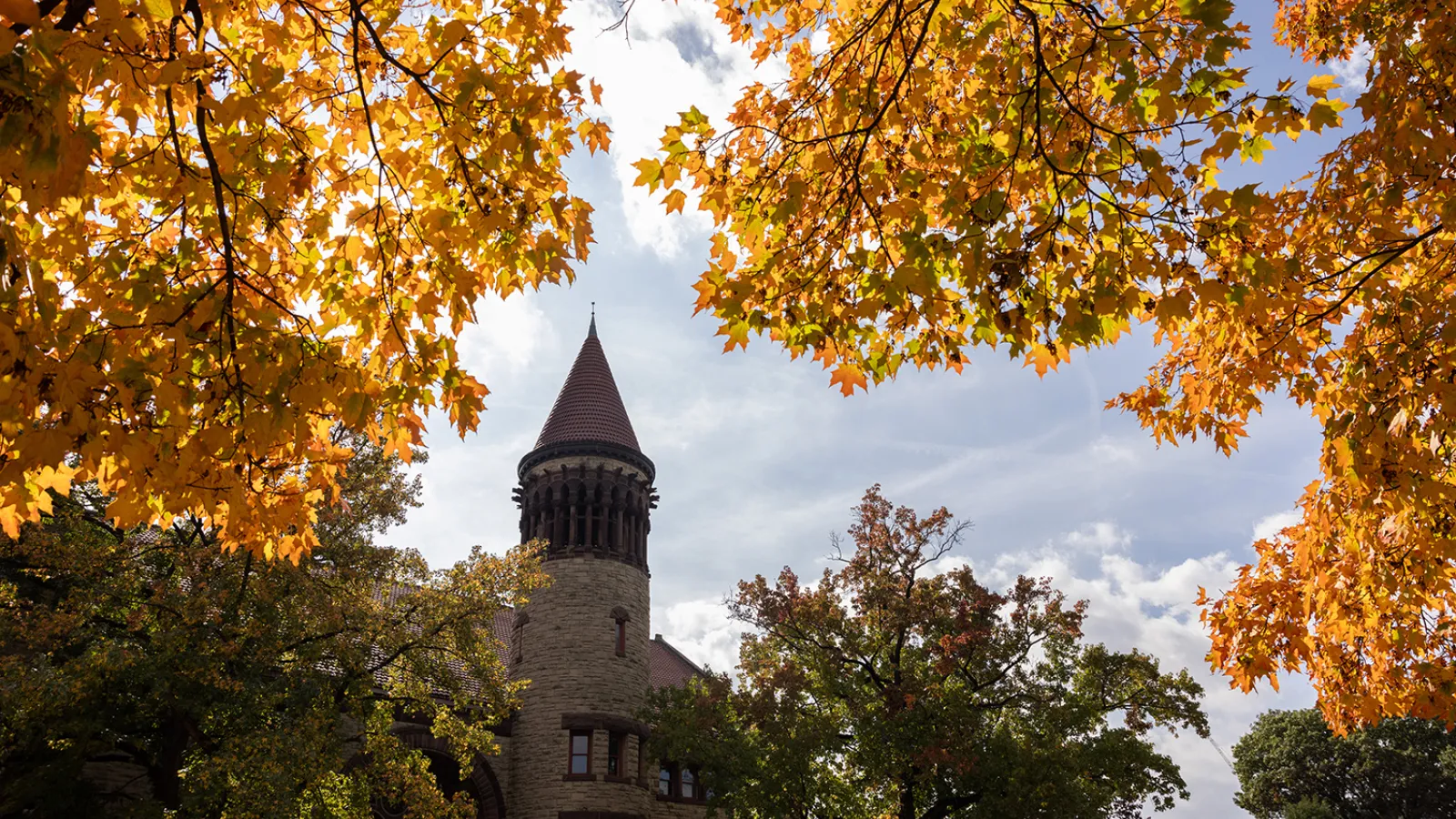 Orton Hall bell tower with yellow autumn foliage in the foreground