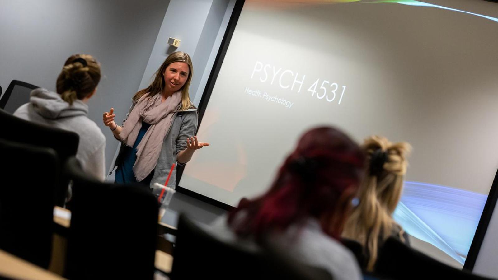 Psychology Professor speaking in front of a course