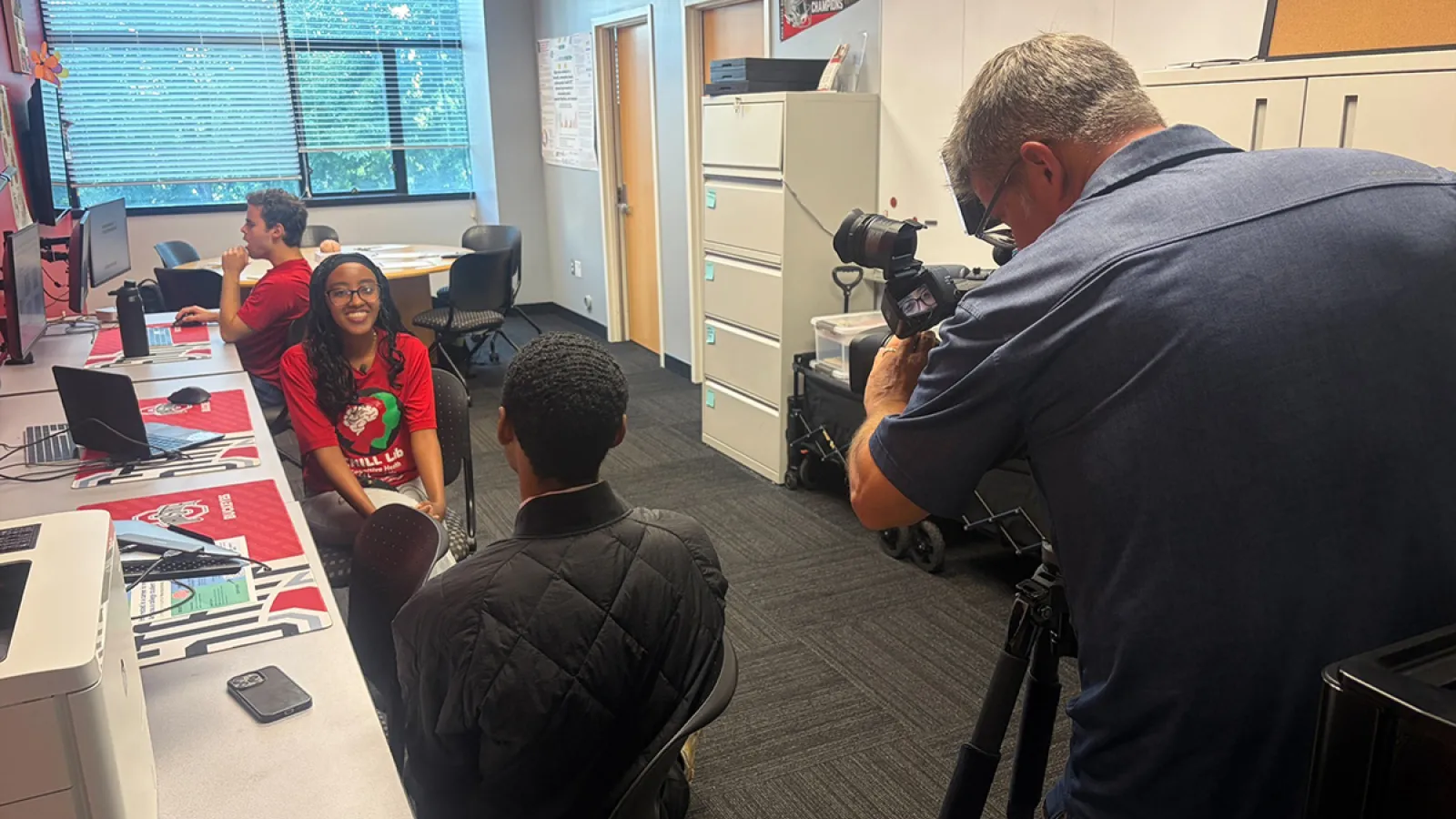 A TV cameraman records Meseret Alemu as she sits and speaks to her mentor