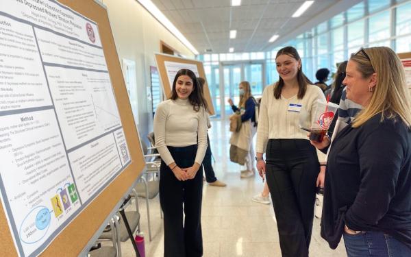 Student presents her research poster to others