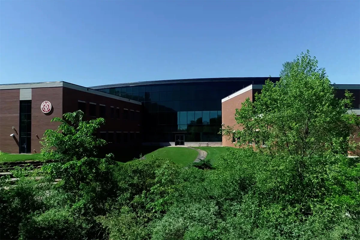 Large brick building with Ohio State seal and lush green trees in front