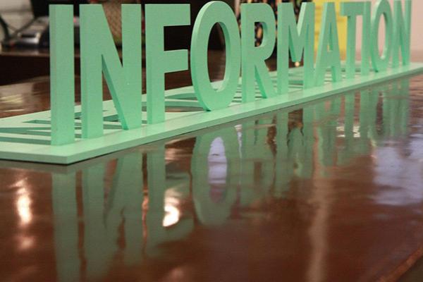 A 3D cut-out of the word "information" sitting on a table